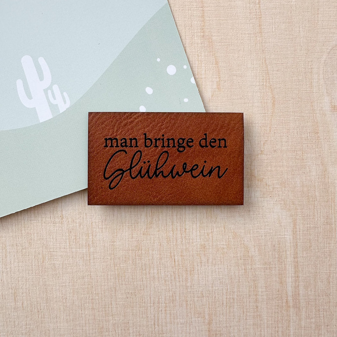 Label aus Kunstleder "Man bringe den Glühwein"