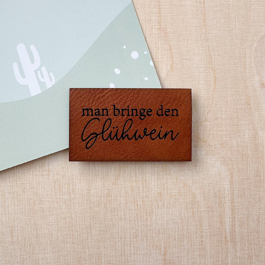 Label aus Kunstleder "Man bringe den Glühwein"