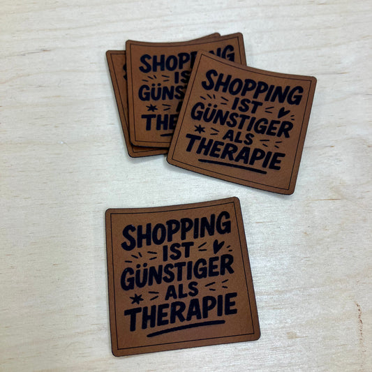 Label aus Kunstleder "Shopping ist günstiger"